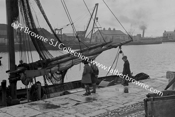 CHILDREN LOOKING AT BOAT IN HARBOUR